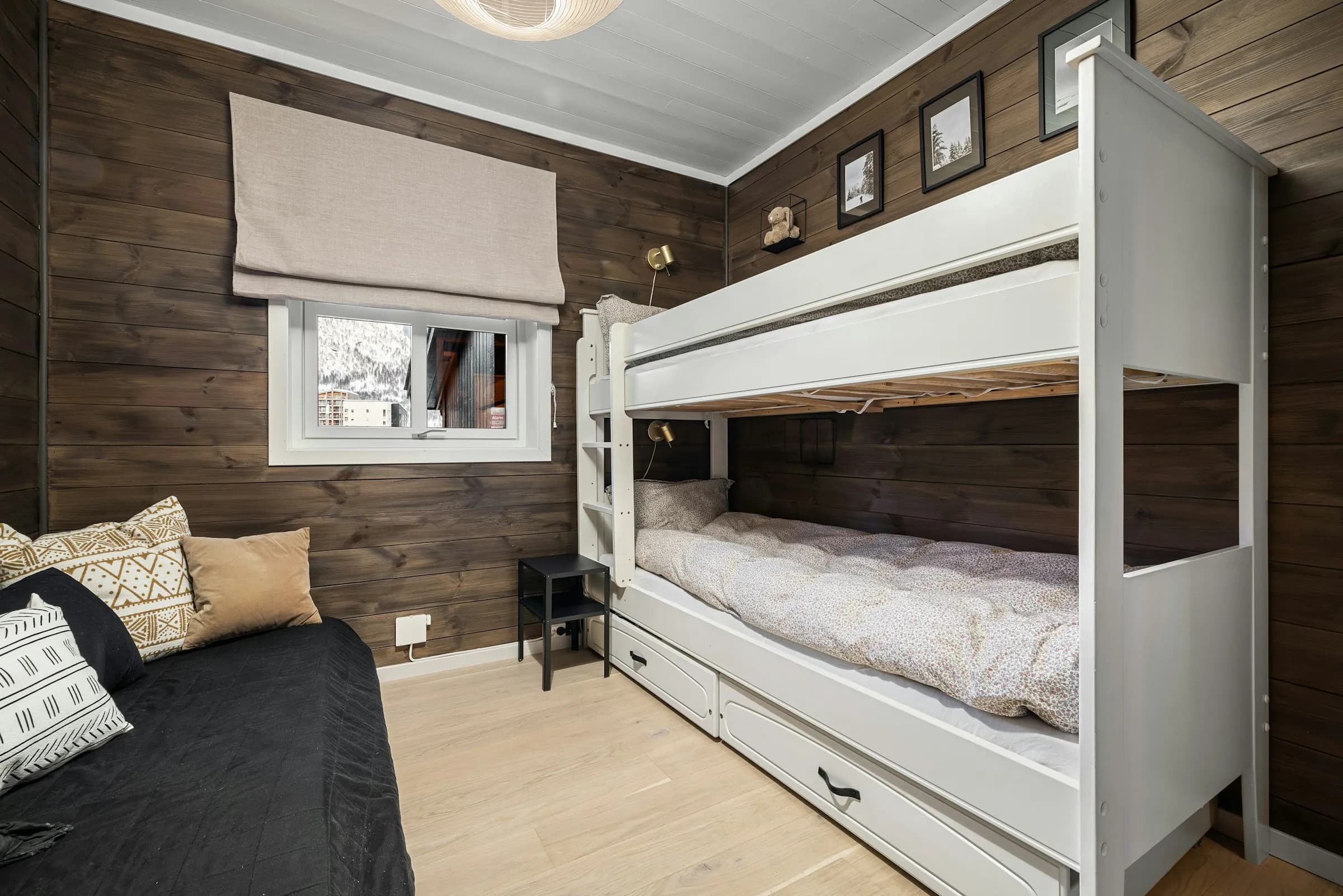 A bunk room with white beds and dark timber walls